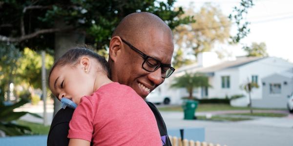 Father with sleeping child. Image courtesy Christina Frigo