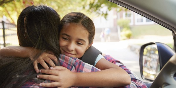 Mom and girl hug at dropoff