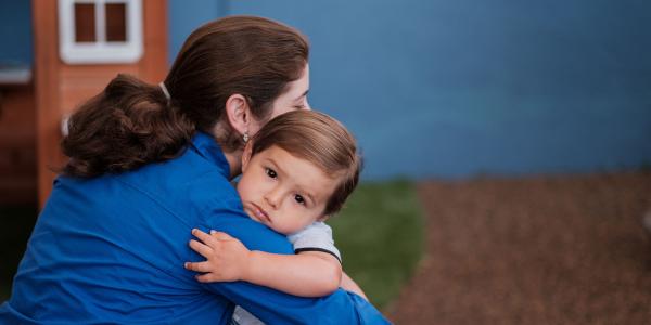 Parent hugging child outside