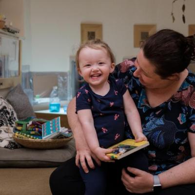 Child sitting with educator and smiling