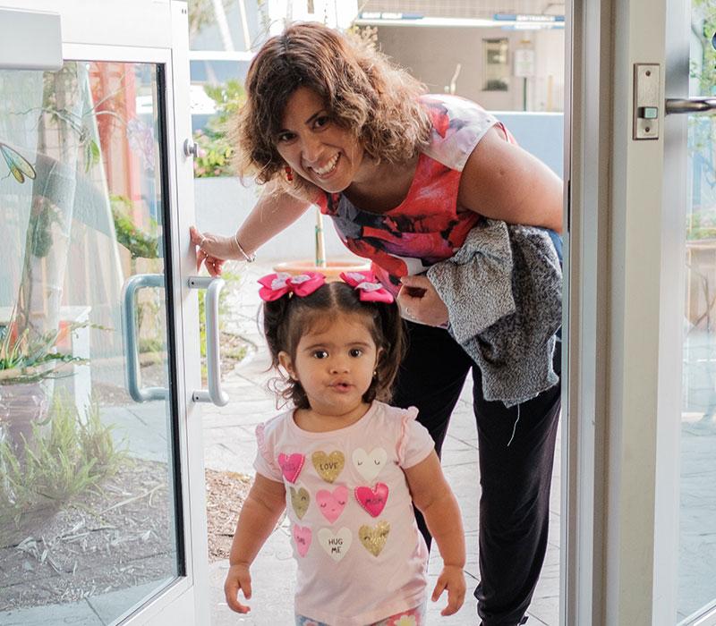 Mom and girl going through door